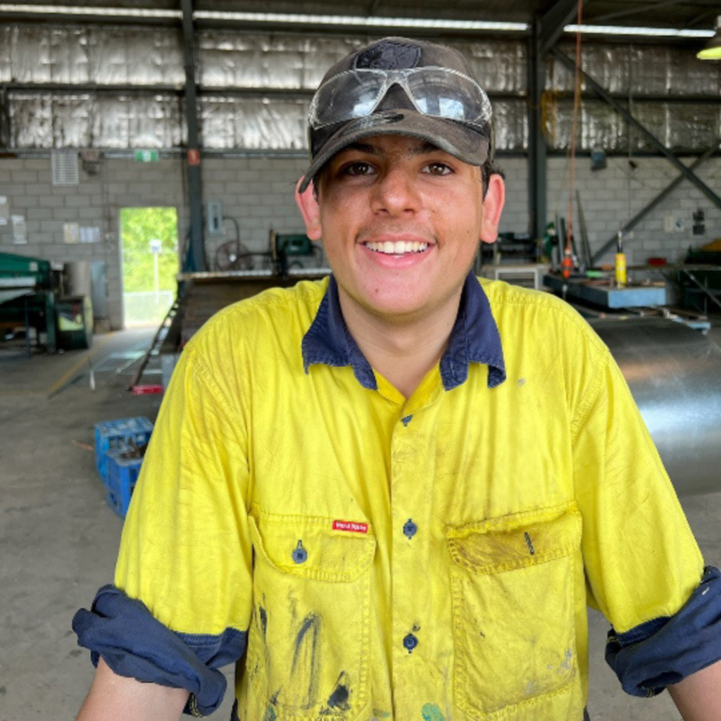 Jaxson wearing safety goggles and uniform in his apprenticeship workplace
